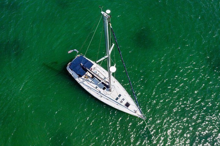 A sailboat on a greenish-blue body of water. 2