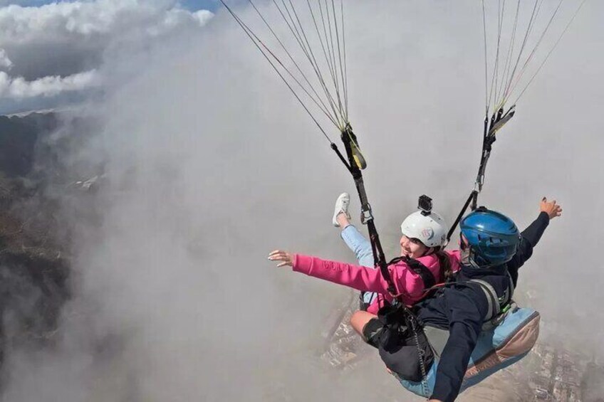 Deux personnes pratiquent le parapente au-dessus d’un paysage montagneux. 1