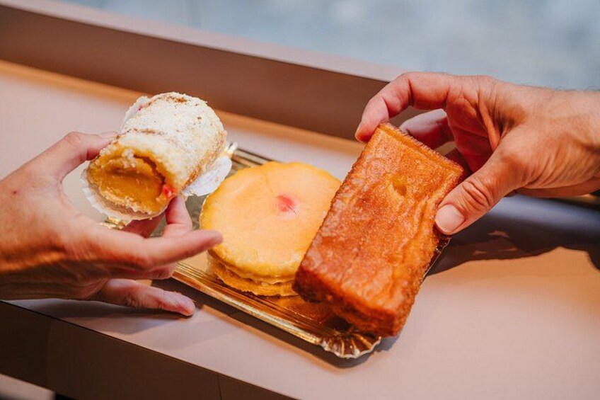 En person holder et indpakket wienerbrød og et rektangulært wienerbrød på en bakke. 3