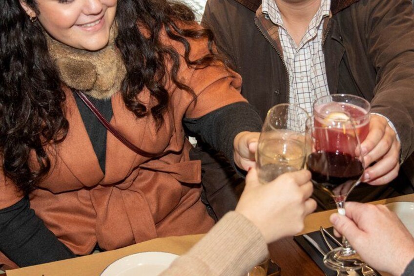 A person holding a wine glass and another holding a glass with a red liquid. 3