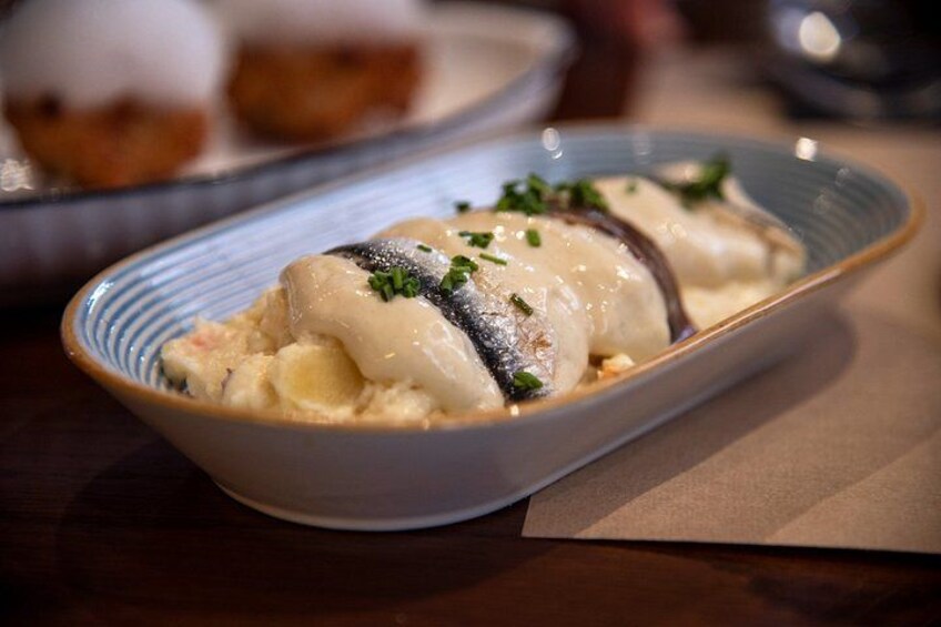 A bowl of food with dumplings and a creamy sauce, garnished with herbs. 3