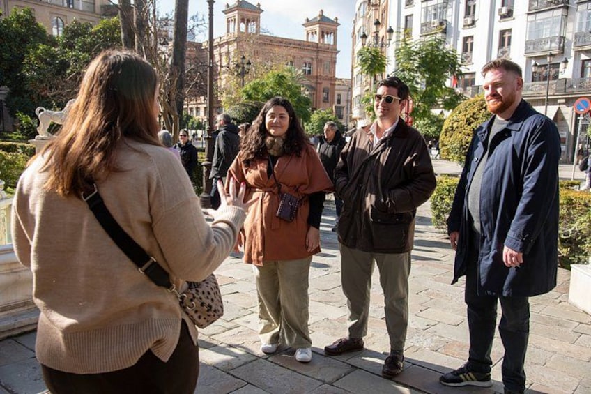 A group of people standing on a paved area with buildings in the background. 5