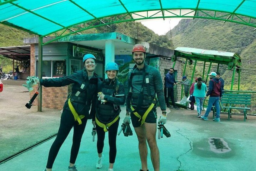 Two people in safety harnesses, a green shelter, and a mountainous landscape. 4