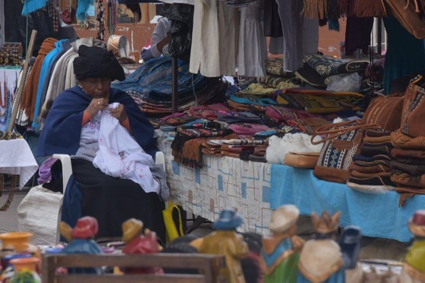 Un étal de marché proposant divers articles en tissu et différents types de sacs. 5