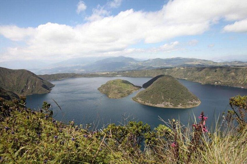 Un lac entouré de collines, sous un ciel dégagé parsemé de quelques nuages. 2