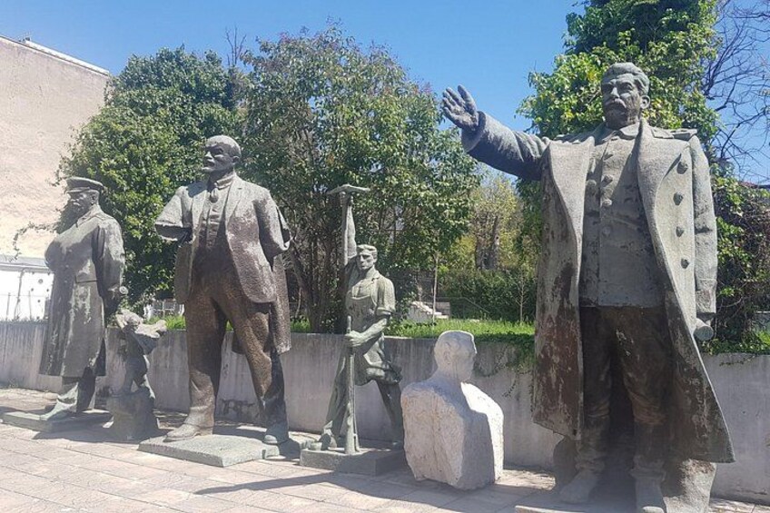 A statue of a man in a suit with outstretched arms, standing on a pedestal. 2