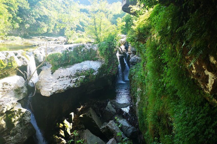 A waterfall cascading over rocks in a forested area. 3
