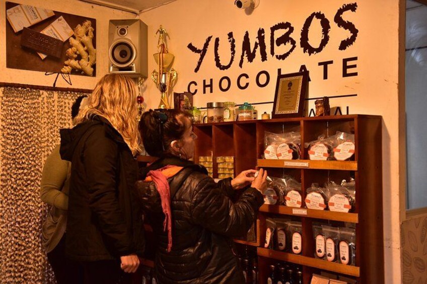 Ein Geschäft mit Regalen voller Schokoladenprodukte und einem Schild, auf dem 'YUMBOS CHOCOLATE' steht. 2