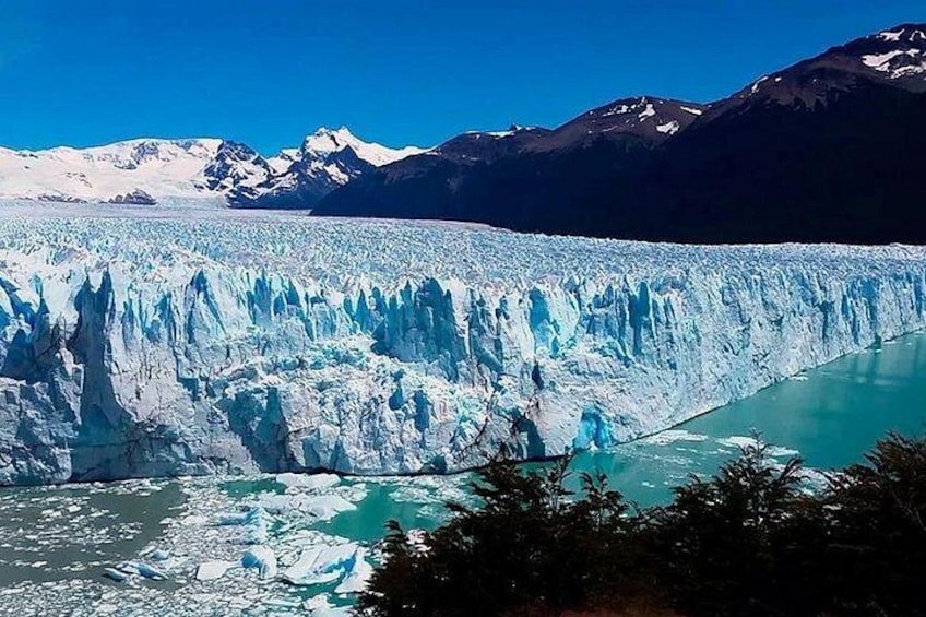 A glacier with turquoise water at its base, surrounded by mountains. 2