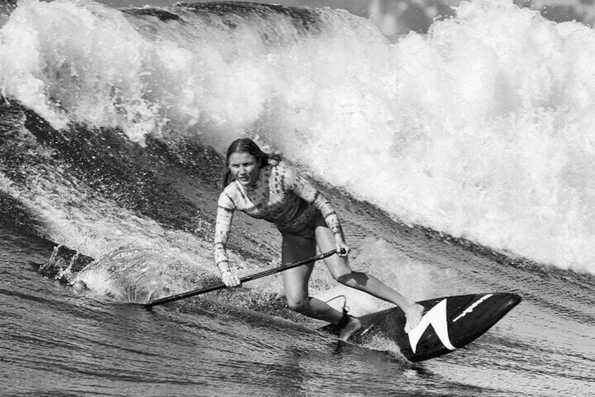 A person paddling on a surfboard in the ocean. 1
