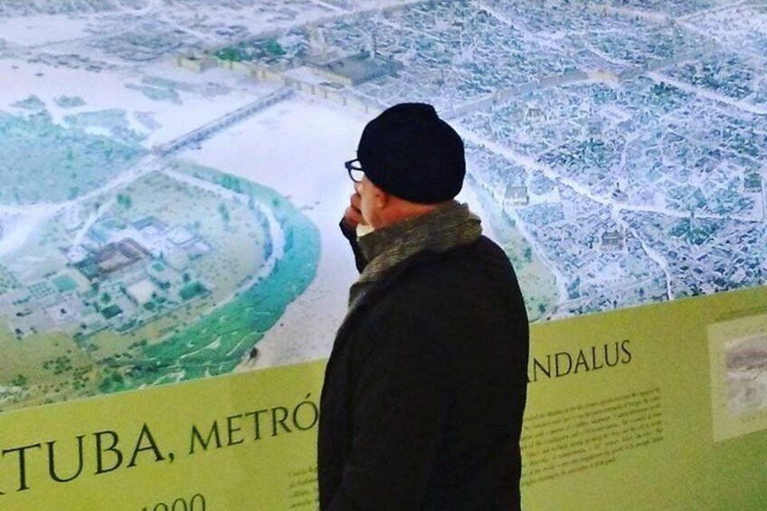 A man standing in front of a map with the text 'TUBA, METRO' and 'INDALUS' visible. 2