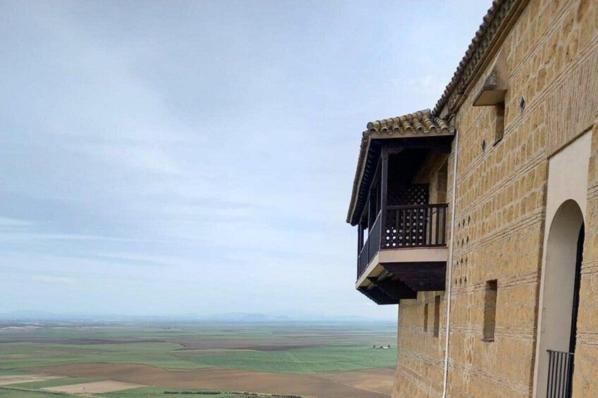 A building with a balcony overlooking a vast landscape. 3