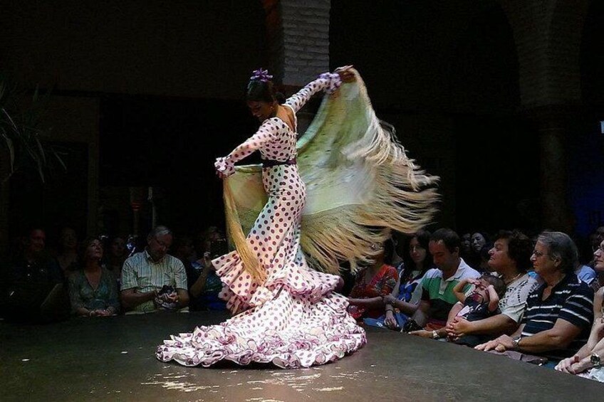 A person performing a dance with a flowing skirt on a stage. 3