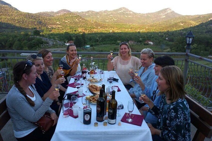 A group of people dining outdoors with a scenic mountain backdrop. 5
