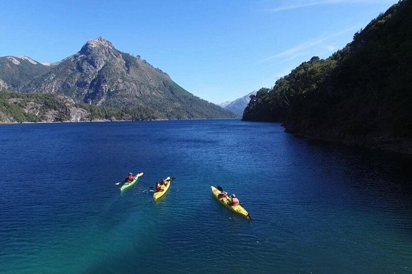 Three kayaks on a calm body of water with mountains in the background. 1