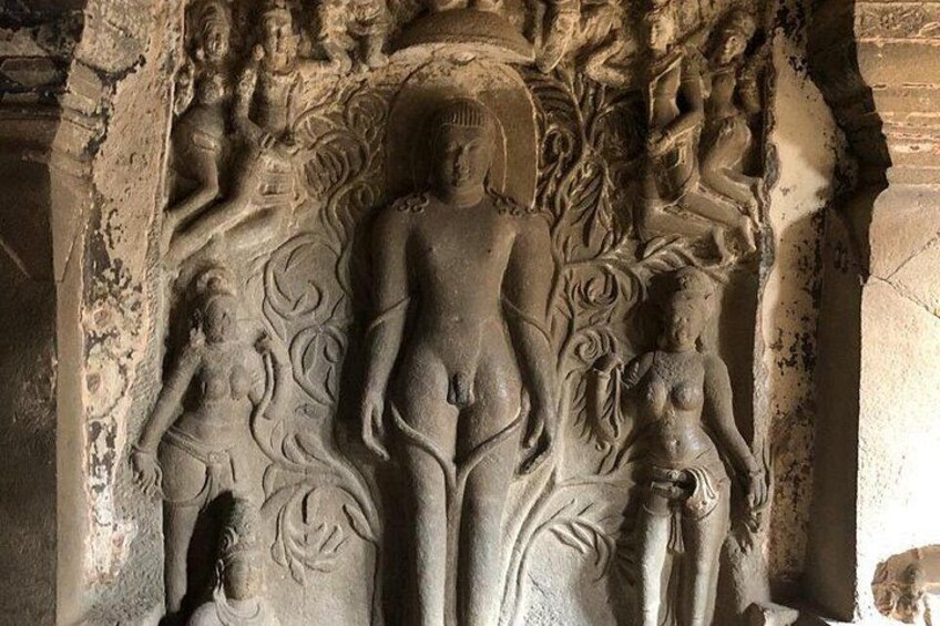 A stone carving of a central figure with attendants, surrounded by intricate designs. 5