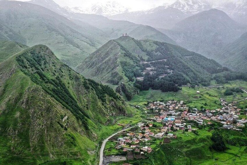 A mountainous landscape with a village nestled in a valley. 4
