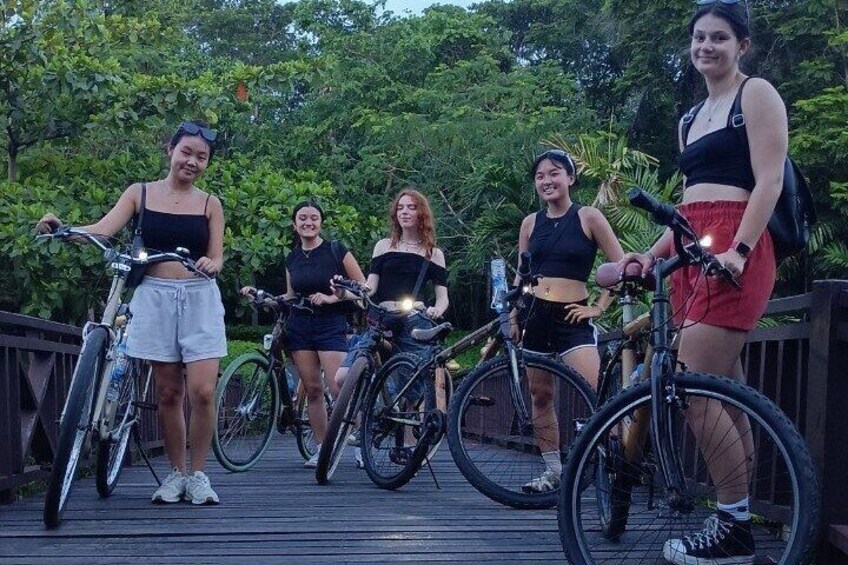 A group of people on a wooden deck with bicycles. 5