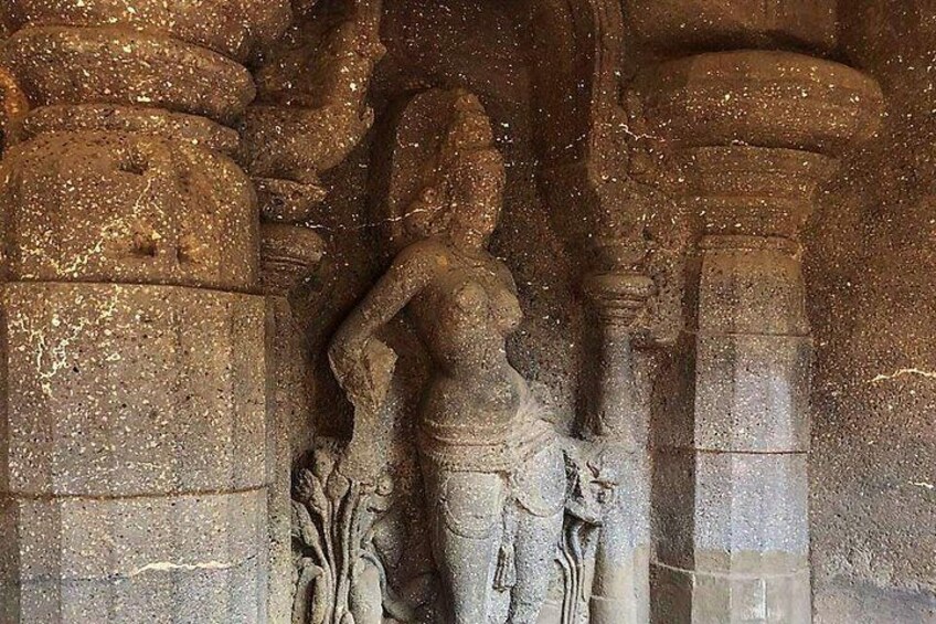 A stone sculpture of a deity with a halo, set within a carved niche. 4