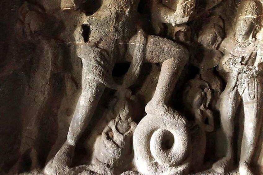 A detailed stone carving of a human figure with a prominent spiral design. 3