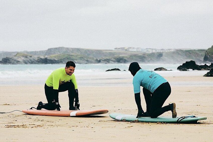 Two people on a beach with surfboards. 2