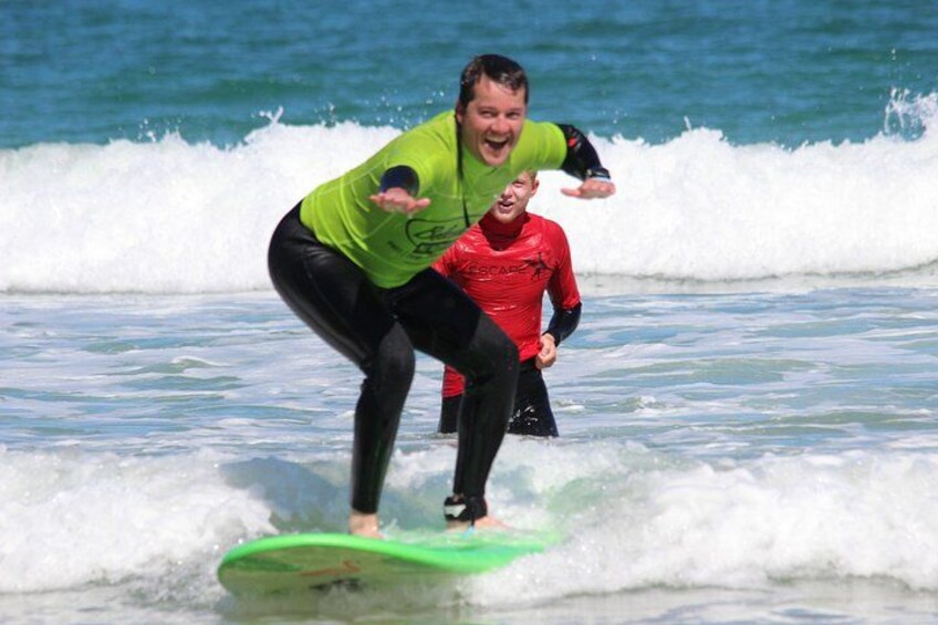 A person surfing on a green board in the ocean. 3