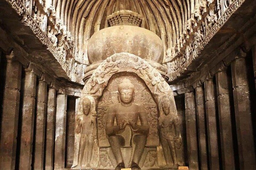 An intricately carved stone Buddha statue within a temple. 1