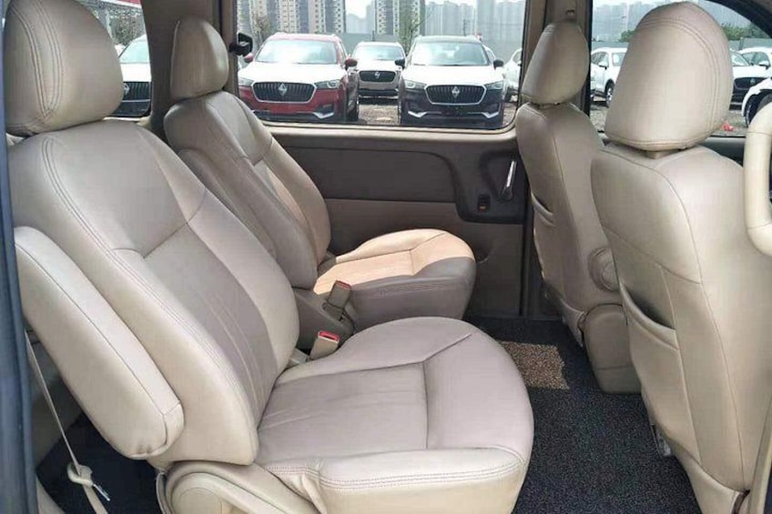A car interior with beige leather seats and a center console. 3