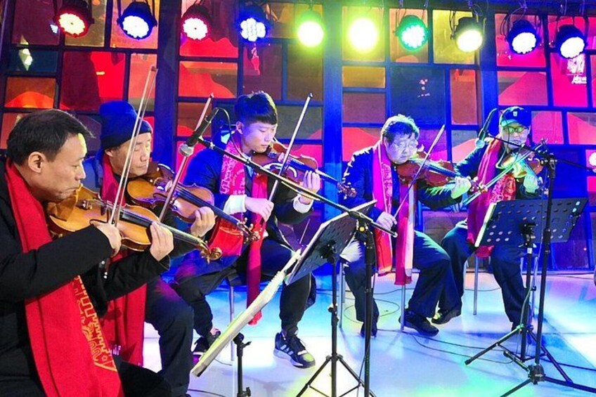 A group of musicians performing on stage with musical instruments. 2