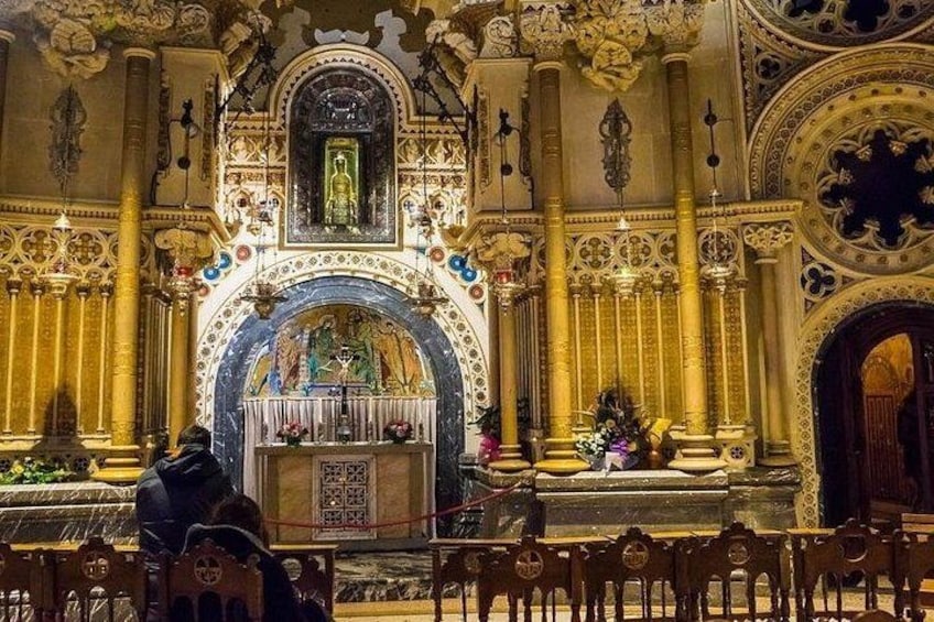 An ornate church interior with a central altar, columns, and detailed ceiling artwork. 1