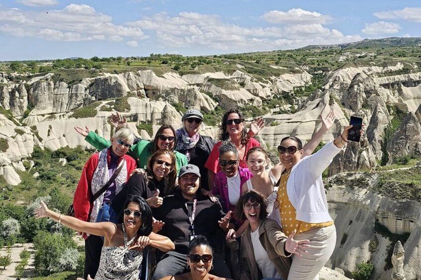 A group of people posing in front of a rocky landscape with white formations. 4