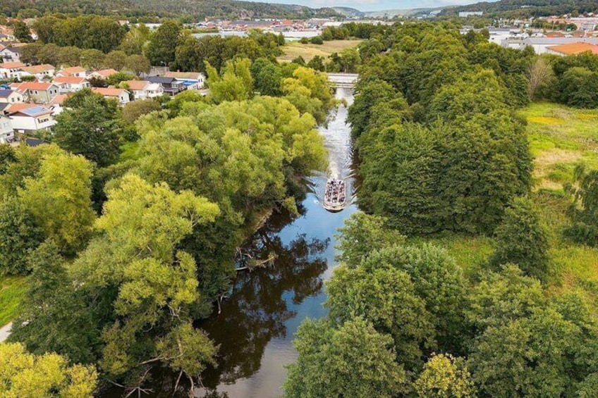 Une rivière serpente à travers une zone boisée dense, et un bateau est amarré au milieu. 5