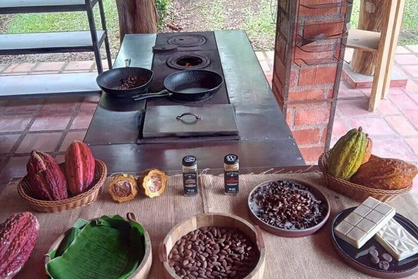 A cooking setup with a gas stove, bowls of beans and cocoa, and various cooking utensils. 1