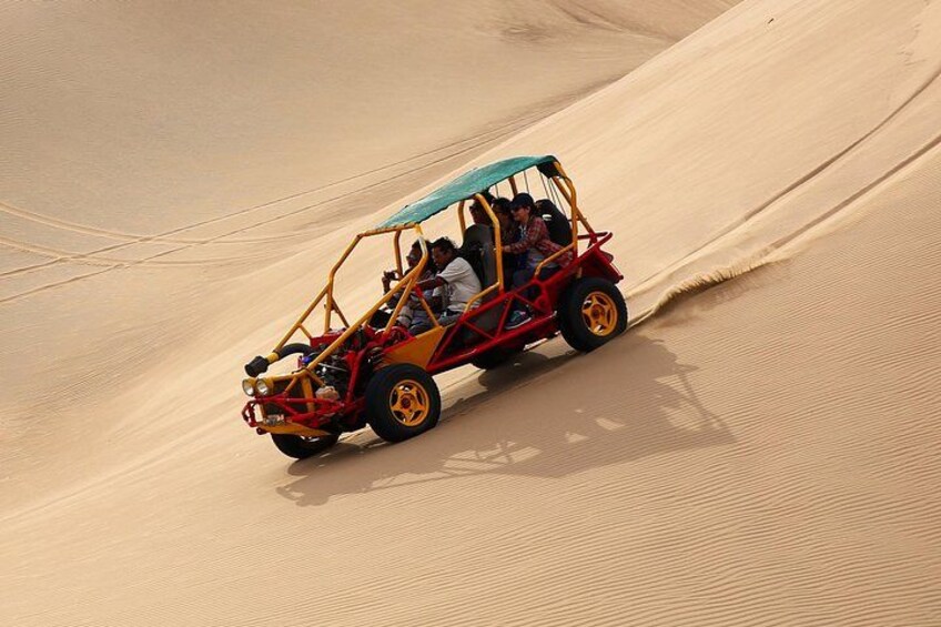 A dune buggy driving on a sand dune. 1