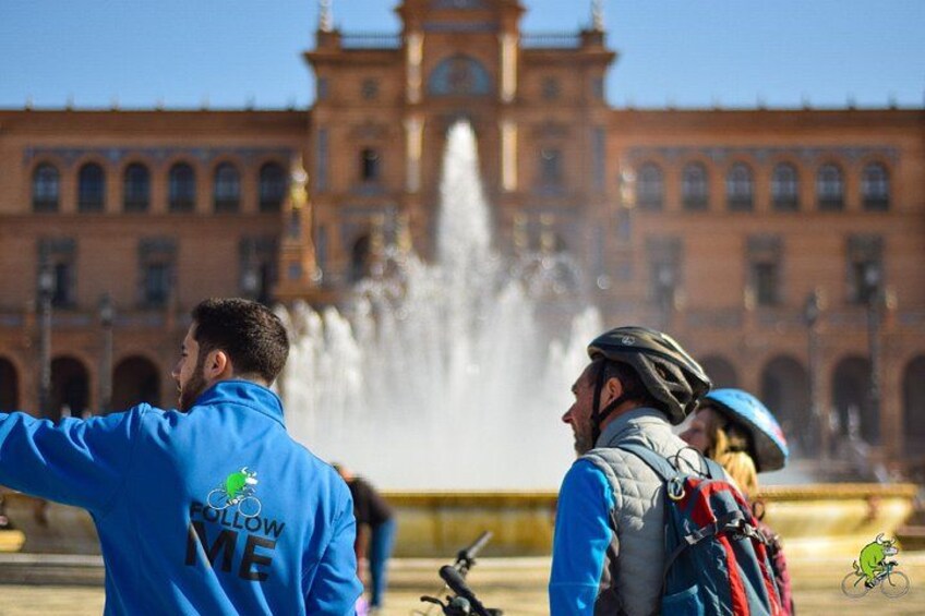 Une fontaine devant un bâtiment historique, avec des personnes portant des vêtements de cycliste. 3