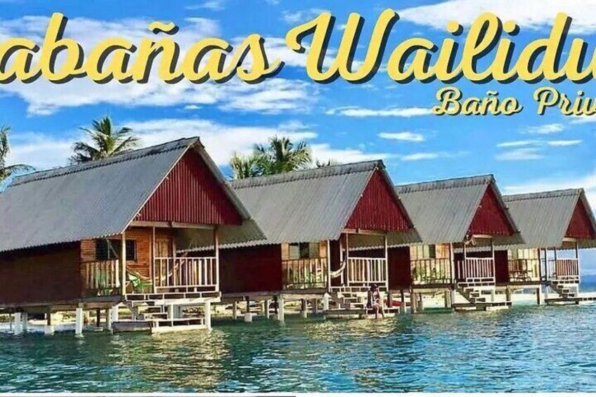 Overwater bungalows with red roofs and wooden structures on stilts over water. 3