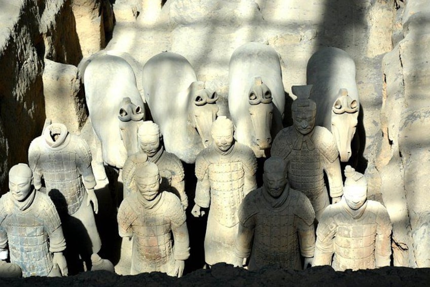 A collection of stone terracotta figures, some with animal heads, arranged in a row. 1