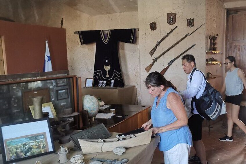 A museum exhibit with artifacts, a map, and a flag. 3