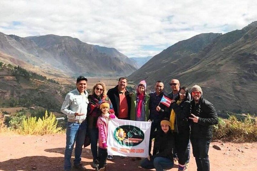 Un gruppo di persone che posa con uno striscione in un paesaggio montuoso. 4