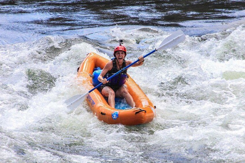 Une personne à bord d’un canot pneumatique navigue sur une rivière à courant rapide. 1