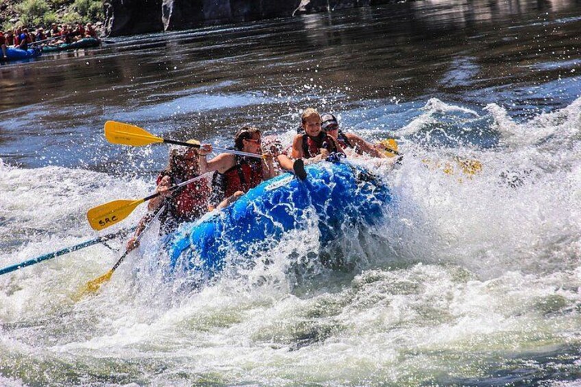 Un groupe de personnes à bord d’un radeau bleu naviguant dans des rapides. 3