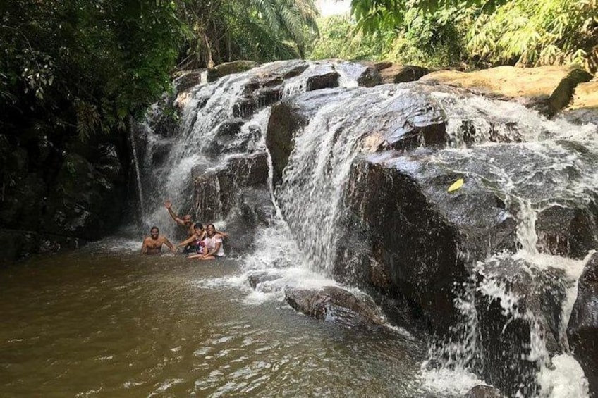 A waterfall with people enjoying the water. 1