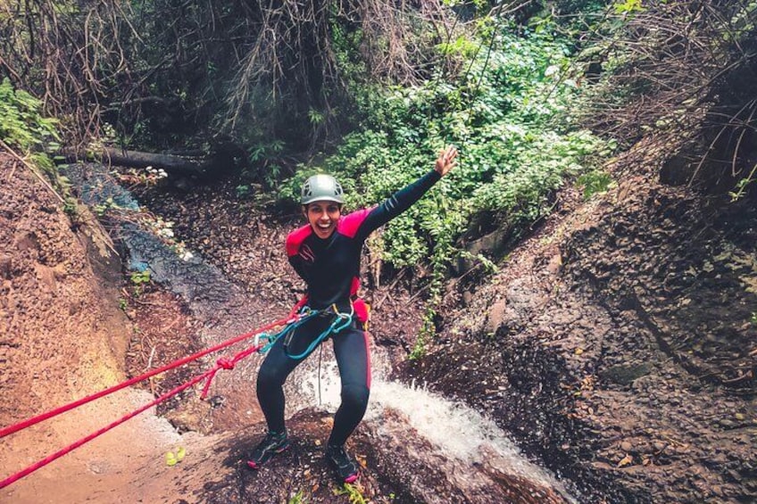 A person rappelling down a rocky slope with a harness and ropes. 1