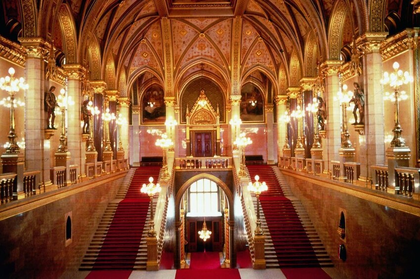 Een rijk versierd kathedraalinterieur met hoge gewelfde plafonds, gouden decoraties en een centraal altaar. 5