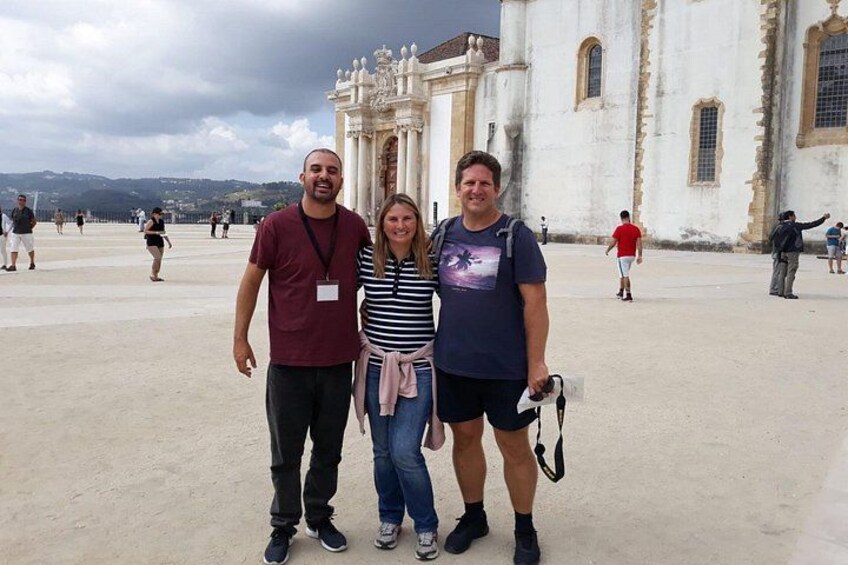 Trois personnes se tiennent devant un bâtiment historique orné de colonnes et d’arcades. 2