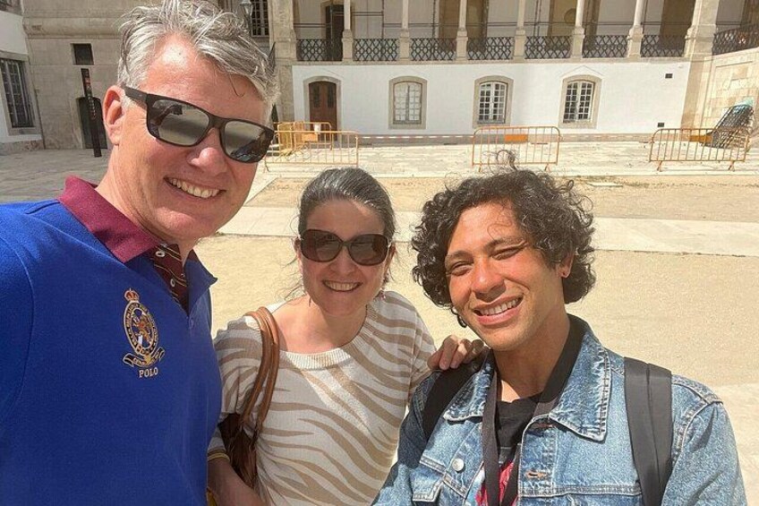 Un groupe de personnes se tient devant un bâtiment doté de colonnes et d’une cour intérieure. 4