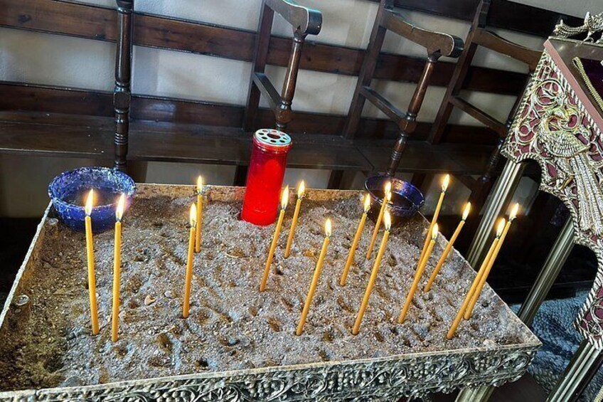 Una composición de velas encendidas sobre una bandeja con textura, una vela roja y un cuenco azul en un ambiente de madera. 3