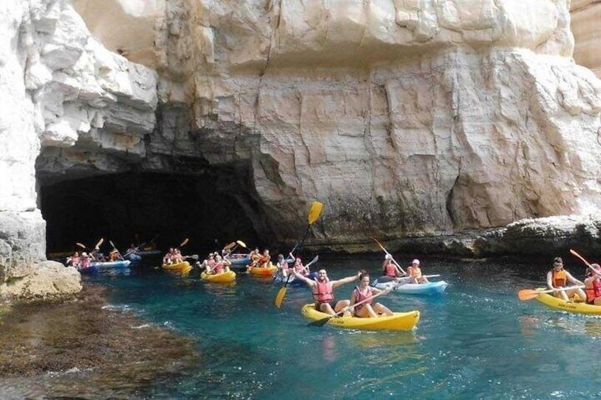 Un grupo de personas haciendo kayak en un canal estrecho con acantilados rocosos a un lado. 4
