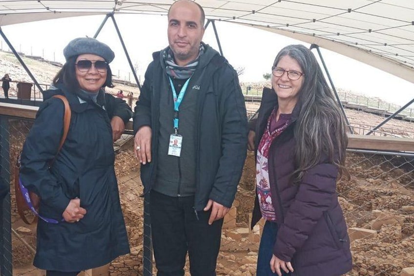 Three people standing under a structure with a metal framework. 4