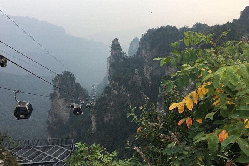 A cable car system in a mountainous area with steep cliffs and dense vegetation. 2